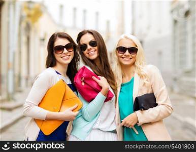 holidays and lifestyle concept - beautiful girls with bags in the ctiy