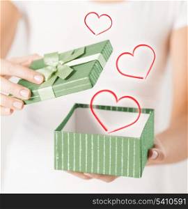 holidays and love concept - close up of woman hands opening gift box