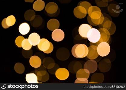 holidays and luxury concept - blurred golden lights over dark background. blurred golden lights over dark background