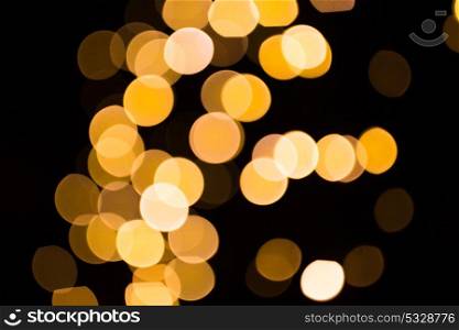 holidays and luxury concept - blurred golden lights over dark background. blurred golden lights over dark background