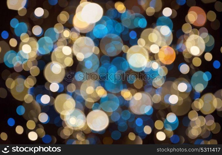 holidays and party concept - blue, yellow and black christmas background with blurred bokeh lights. christmas background with bokeh lights