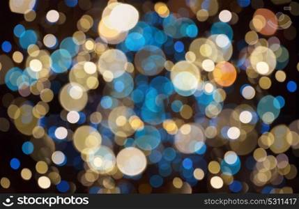 holidays and party concept - blue, yellow and black christmas background with blurred bokeh lights. christmas background with bokeh lights