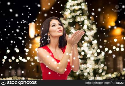 holidays and people concept - beautiful sexy woman in red dress. beautiful woman in red dress over christmas tree