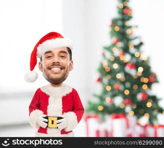holidays and people concept - happy smiling young man in santa claus costume over christmas tree and presents background (funny cartoon style character with big head). smiling man in santa costume over christmas tree