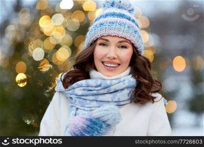 holidays and people concept - happy young woman walking in christmas city in winter. happy woman walking in christmas city in winter