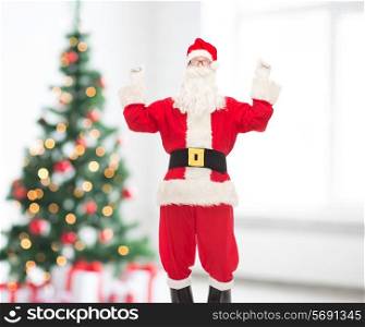 holidays and people concept - man in costume of santa claus having fun over living room and christmas tree background