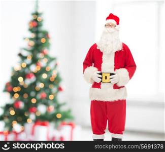 holidays and people concept - man in costume of santa claus over living room and christmas tree background