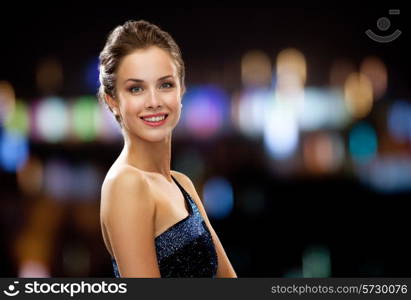 holidays and people concept - smiling woman in evening dress over night city lights background