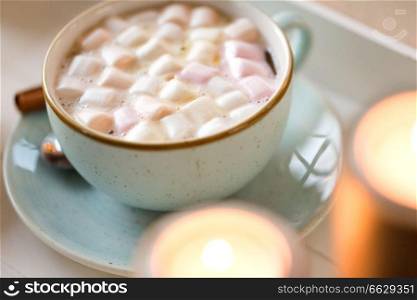 holidays and still life concept - close up of hot chocolate with marshmallow and candles. close up of hot chocolate with marshmallow