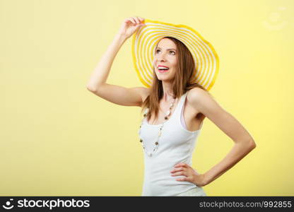 Holidays and summer fashion. Woman in big yellow hat. Portrait of charming female on bright background.