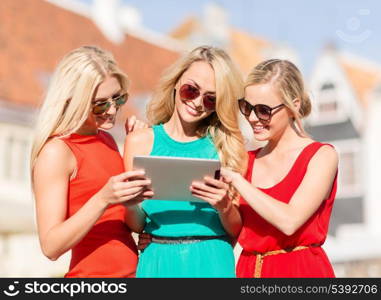 holidays and tourism concept - beautiful blonde girls toursits looking into tablet pc in the city