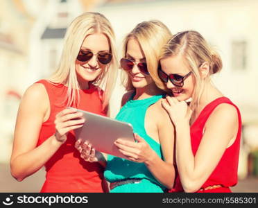 holidays and tourism concept - beautiful blonde girls toursits looking into tablet pc in the city