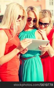 holidays and tourism concept - beautiful blonde girls toursits looking into tablet pc in the city