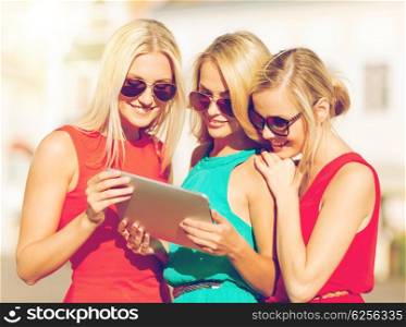 holidays and tourism concept - beautiful blonde girls toursits looking into tablet pc in the city. beautiful girls toursits looking into tablet pc