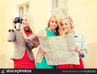 holidays and tourism concept - beautiful blonde women with tourist map and photo camera in the city