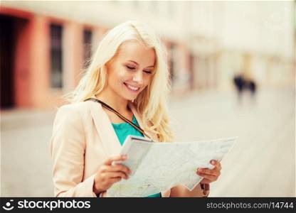 holidays and tourism concept - beautiful girl looking into tourist map in the city