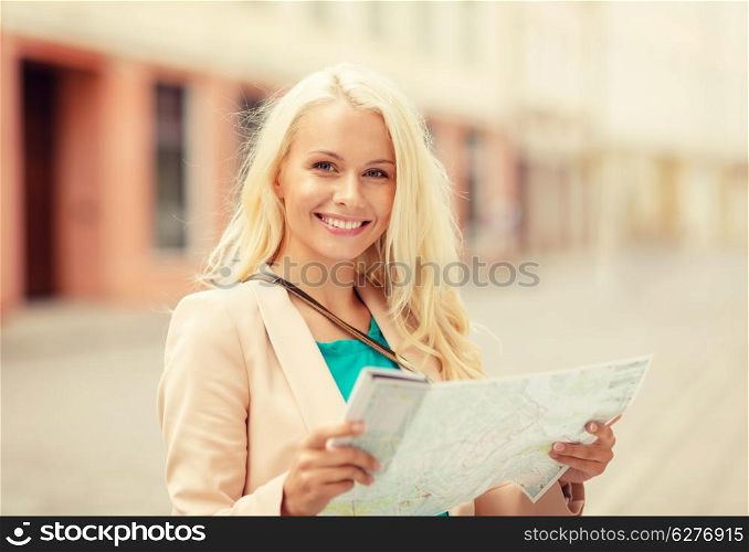holidays and tourism concept - beautiful girl with tourist map in the city
