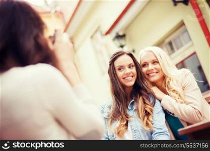 holidays and tourism concept - beautiful girls taking picture in cafe in city