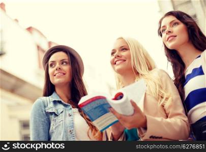holidays and tourism concept - three beautiful girls with tourist book and camera in the city