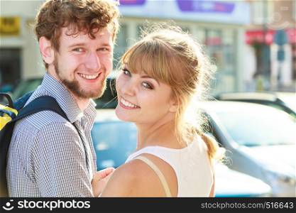 Holidays and tourism concept. Young tourist couple with backpack traveling together having fun, two friends on vacation in city at sunny day. Tourist couple traveling together having fun