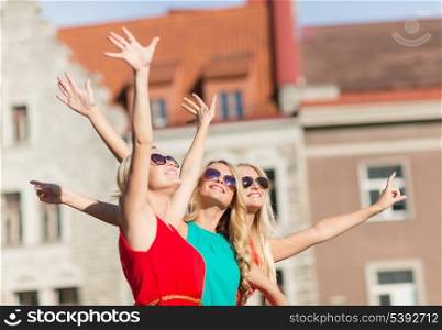 holidays and tourism, friends, hen party, blonde girls concept - three beautiful women in the city waving hands