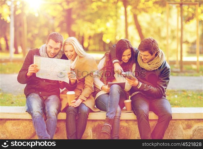 holidays and tourism, navigation concept - group of friends or couples with tourist map and tablet pc computer in autumn park