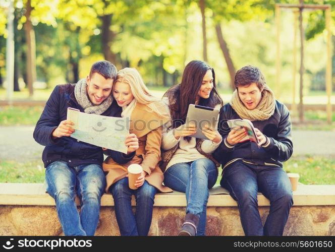 holidays and tourism, navigation concept - group of friends or couples with tourist map and tablet pc computer in autumn park