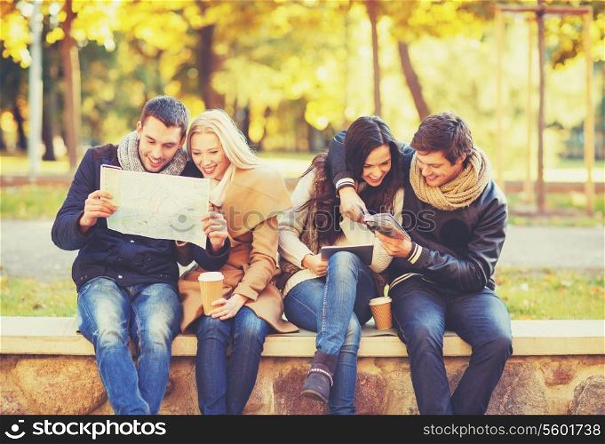 holidays and tourism, navigation concept - group of friends or couples with tourist map and tablet pc computer in autumn park