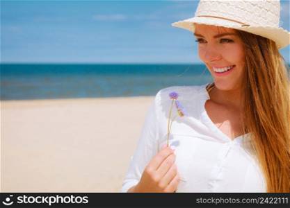 Holidays and vacation. Lovely cute woman tourist holding little flower on sunny beach. Young girl enjoy her free time on seaside.. Smiling girl with flower on beach
