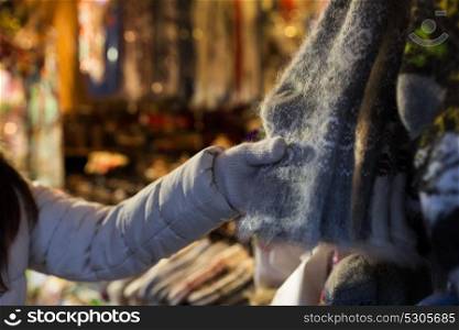 holidays and winter clothes concept - close up of woman buying woolen socks at christmas market. woman buying woolen socks at christmas market