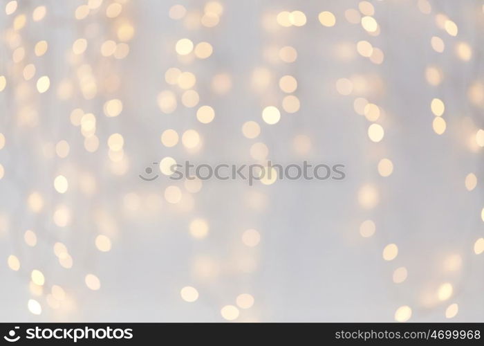 holidays, background and illumination concept - blurred golden christmas decoration or garland lights bokeh