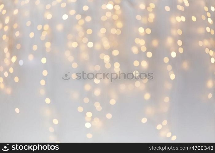 holidays, background and illumination concept - blurred golden christmas decoration or garland lights bokeh