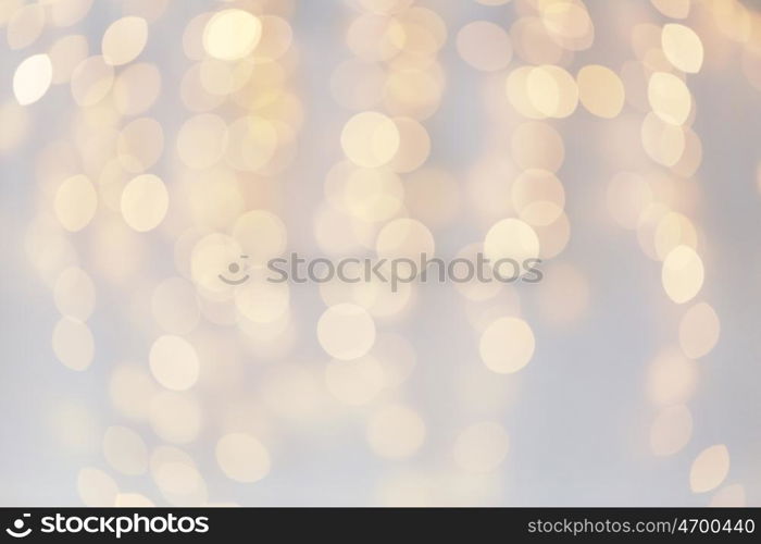 holidays, background and illumination concept - blurred golden christmas decoration or garland lights bokeh