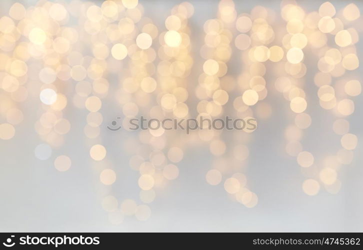 holidays, background and illumination concept - blurred golden christmas decoration or garland lights bokeh