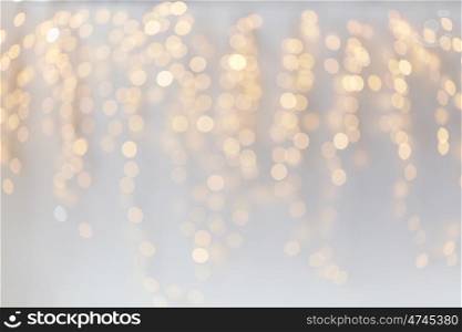 holidays, background and illumination concept - blurred golden christmas decoration or garland lights bokeh