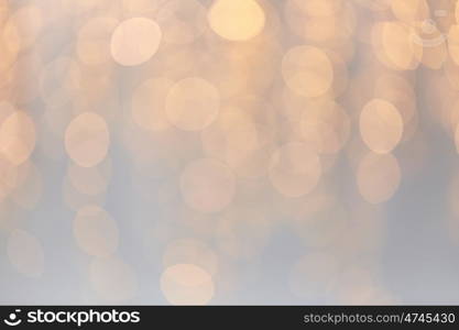 holidays, background and illumination concept - blurred golden christmas decoration or garland lights bokeh