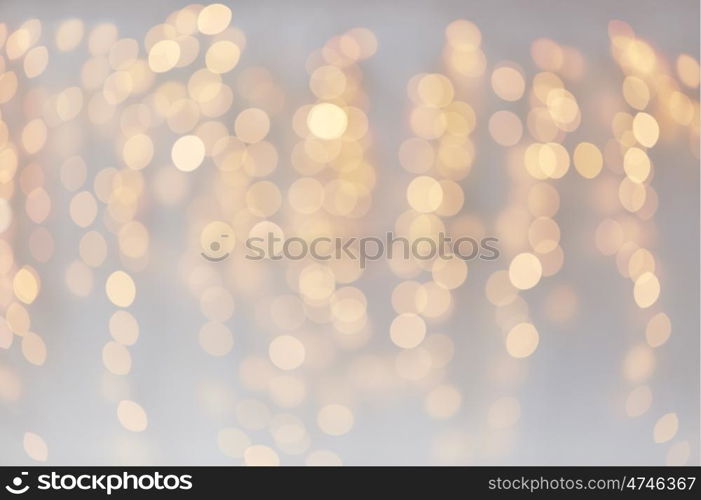 holidays, background and illumination concept - blurred golden christmas decoration or garland lights bokeh