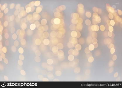 holidays, background and illumination concept - blurred golden christmas decoration or garland lights bokeh