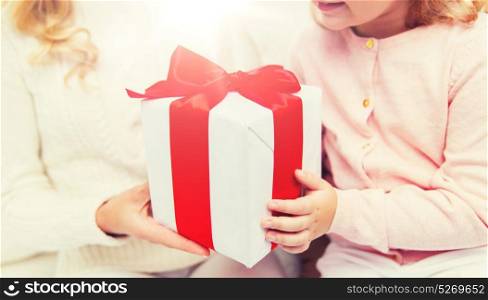 holidays, birthday, christmas, children and family concept - close up of mother and little girl with gift box at home. close up of mother and little girl with gift box