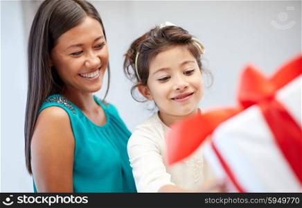holidays, birthday family, childhood and people concept - happy mother and little girl with gift box at home