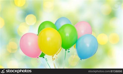holidays, birthday, party and decoration concept - bunch of inflated colorful helium balloons over green summer lights background