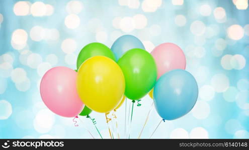 holidays, birthday, party and decoration concept - bunch of inflated colorful helium balloons over blue lights background