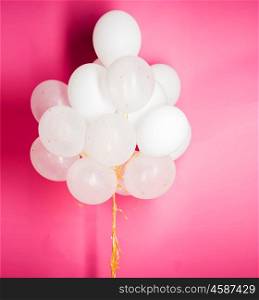 holidays, birthday, party and decoration concept - close up of inflated white helium balloons over pink background