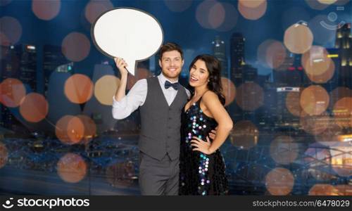 holidays, celebration and communication concept - happy couple hugging at party and holding blank text bubble banner over singapore city night lights background. happy couple at party holding text bubble banner. happy couple at party holding text bubble banner