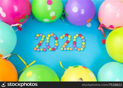holidays, celebration and decoration concept - 2020 new year party date with colorful balloons on blue background. new year 2020 party date with balloons