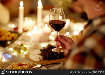 holidays, celebration and people concept - friends having christmas dinner party and drinking non-alcoholic red wine at home. friends drinking red wine at christmas party