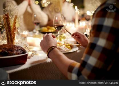 holidays, celebration and people concept - man with group of friends having christmas dinner at home. man having christmas dinner at home