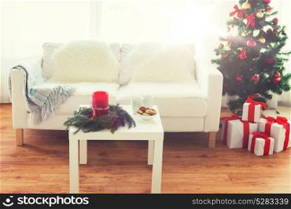 holidays, celebration, decoration and interior concept - sofa, table and christmas tree with gifts at home. sofa, table and christmas tree with gifts at home