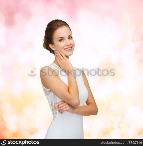 holidays, celebration, wedding and people concept - smiling woman in white dress wearing diamond ring over pink lights background