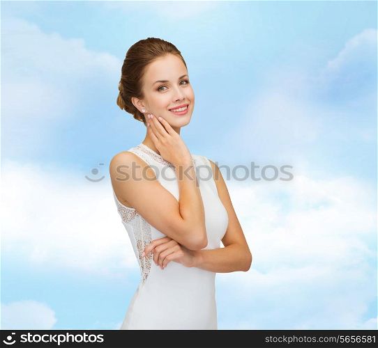 holidays, celebration, wedding and people concept - smiling woman in white dress wearing diamond ring over blue cloudy sky background